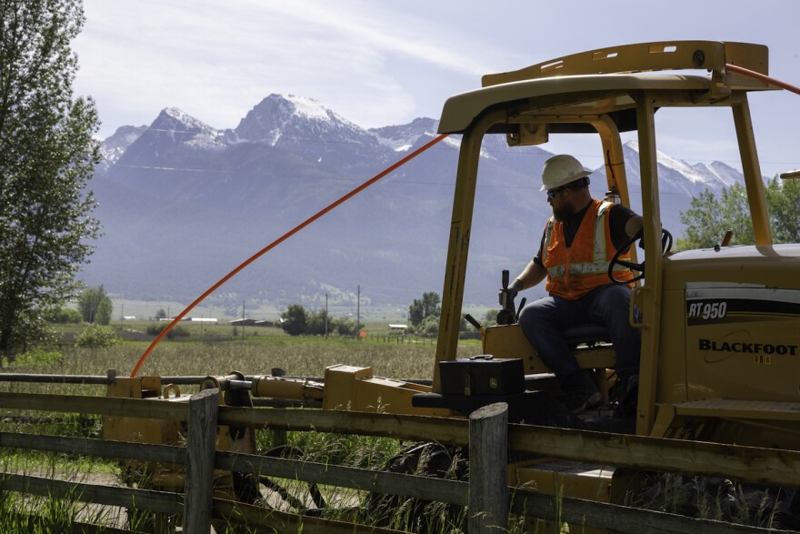 A Blackfoot Communications employee installs conduit for fiber optic cable near St. Ignatius, Montana, June 2020.