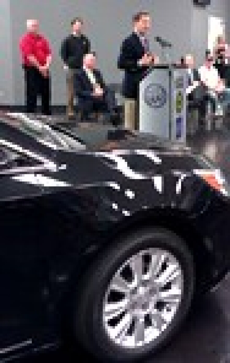 Is car the star? Kansas Governor Sam Brownback at podium of Fairfax Plant. Buick LaCrosse in foreground.