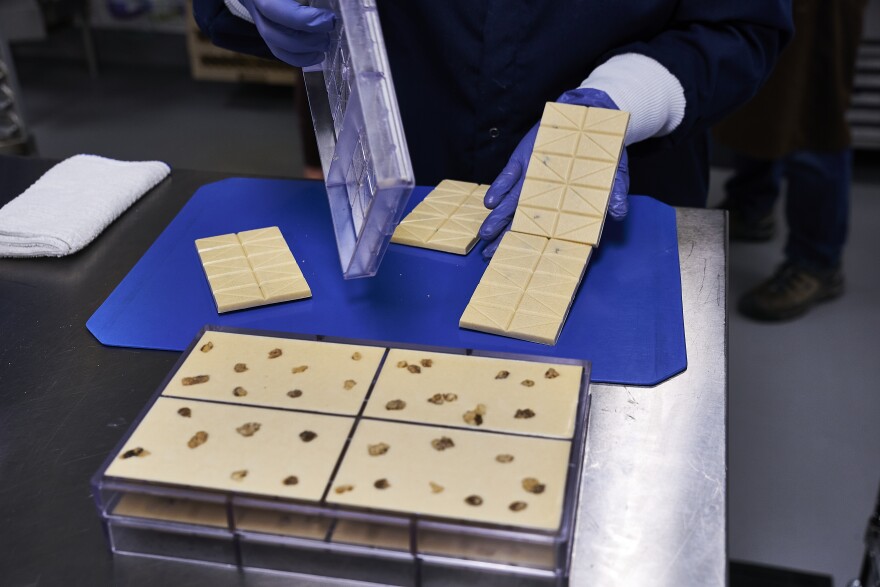 Jessica Nelson, kitchen Lead, demoulding chocolate bars and inspecting them before they go to packaging.