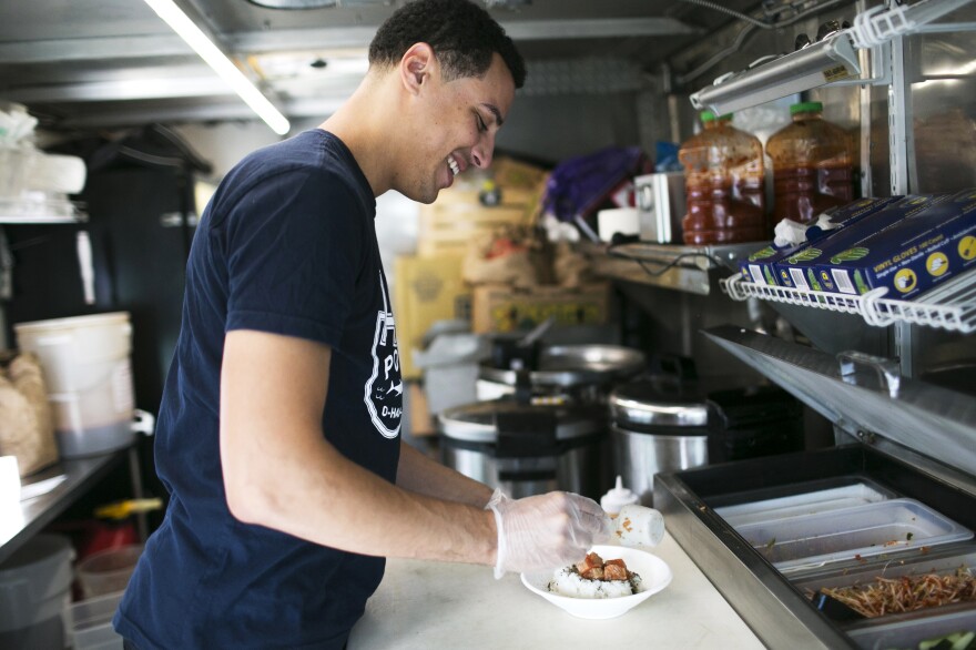 Nile Woodson prepares a Hawaiian-style dish in his food truck, Hai Poké, in Columbus.