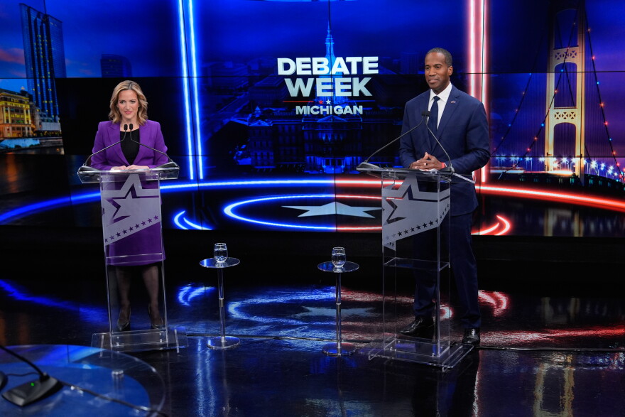 Democratic gubernatorial nominee and Michigan Secretary of State Jocelyn Benson, left, joins with with Rep. John James, R-Mich, Republican gubernatorial candidate during a televised debate on Tuesday, Oct. 6, 2026, at WOOD-TV, in Grand Rapids, Mich. (AP Photo/Paul Sancya, Pool)