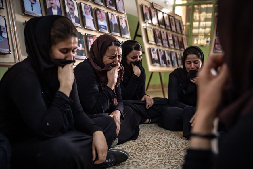 Women from Kocho weep as they remember family members killed in the genocide that began in August 2014, when ISIS declared Yazidis infidels.
