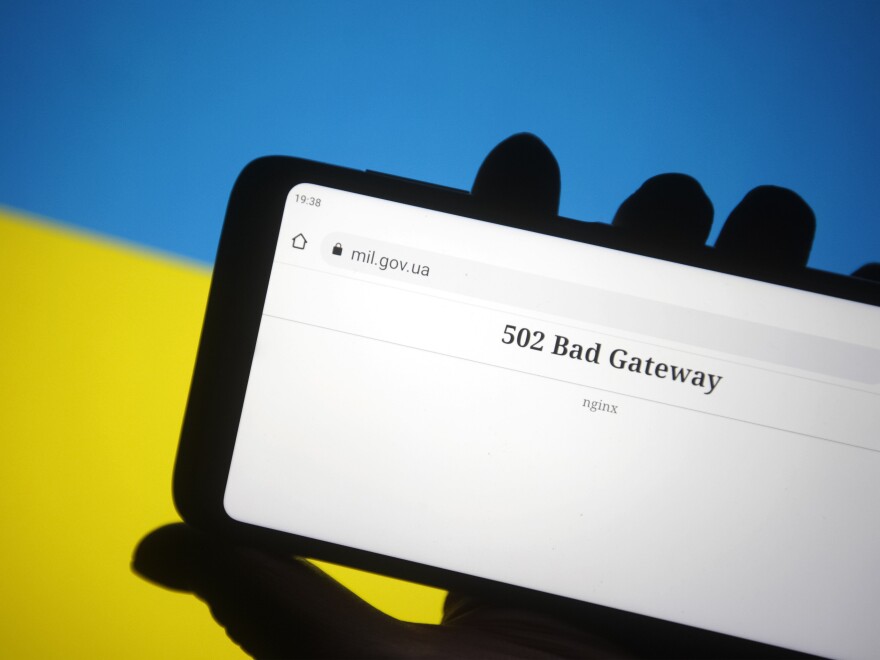 In this photo illustration, the 502 Bad Gateway message is seen on Ministry of Defence of Ukraine official webpage displayed on a smartphone screen and flag of Ukraine in the background.