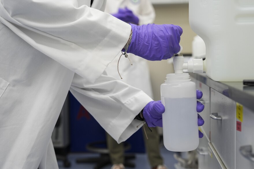 FILE - Logan Feeney pours a water sample with forever chemicals, known as PFAS, into a container for research, April 10, 2024, at a U.S. Environmental Protection Agency lab in Cincinnati.