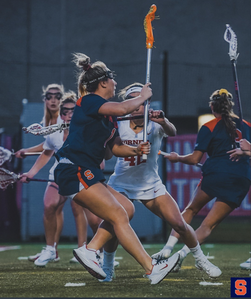 Freshman attacker Olivia Adamson (#1, blue) rifles a pass against the Cornell defense