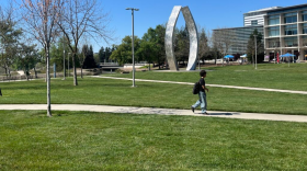 A student walks in front of the "Beginnings Sculpture" on the UC Merced campus on Thursday, March 26, 2026.