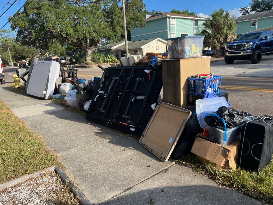Tables, mattresses and other debris on the side of a road.