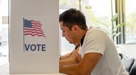 Hispanic Person Voting in Election Booth. a young man focused on voting in an election booth during a United States election. elections, democracy, civic participation, and the voting process.