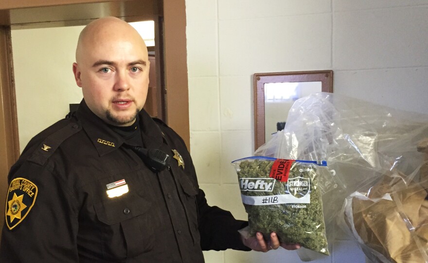 In the evidence room at the courthouse in Deuel County, Neb., Sheriff Adam Hayward holds up a 1-pound bag of marijuana confiscated during a recent traffic stop.
