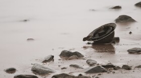 World War era Brodie helmet on beach.
