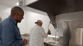 Calvin Moore (left) looks on as Jeff Marlow (right) demonstrates some of the new kitchen's features.
