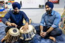 Talvinder Singh watches as his son, Ranveer, plays the tabla at the Gurdwara Guru Nanak Darbar in Medford, Mass. (Robin Lubbock/WBUR)