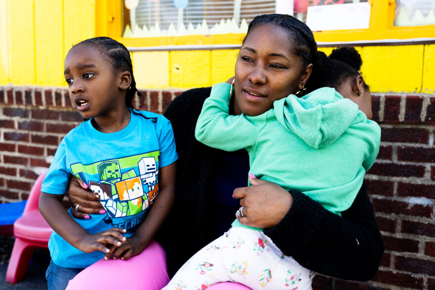 Owner Candace King embraces Beginning Steps Daycare students, on Monday, April 10, 2023, during outdoor play time at the childcare center in Penrose.
