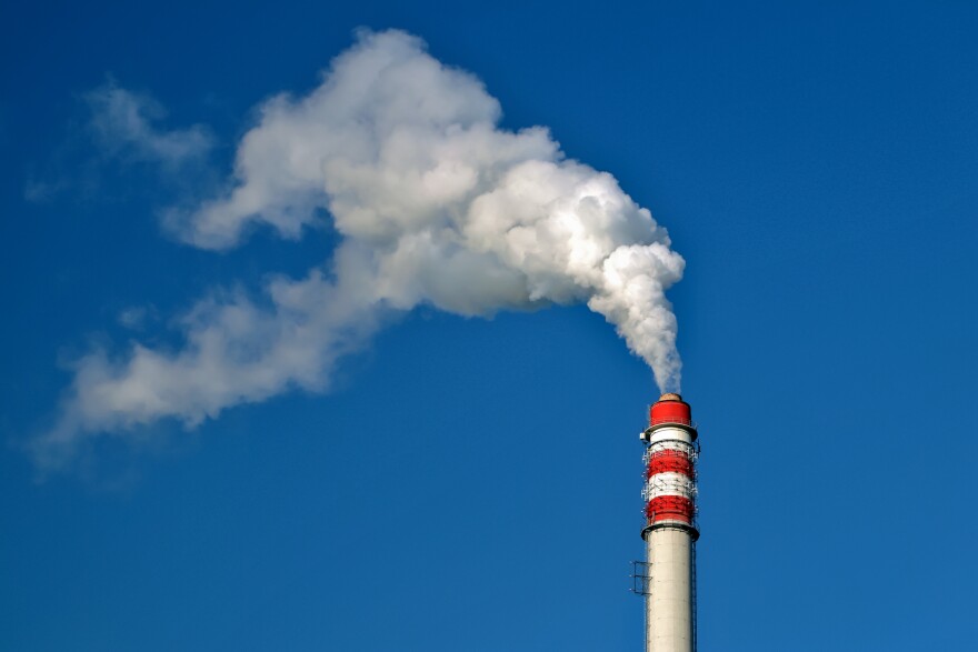 A smoke stack releases white smoke. 