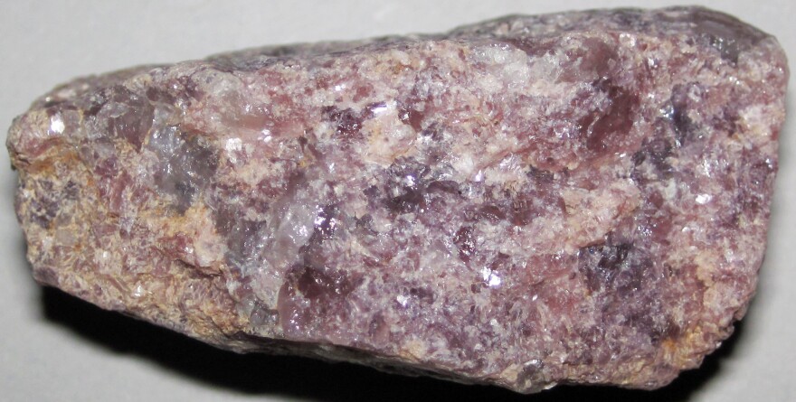 ISU Distinguished Professor Dave Malone works with geological surveys in several states to find and map concentrations of strategic minerals for the U.S. The muscovite mica in this rock is pinkish-rosy-lavender colored. "Ordinary" muscovite is clear. The coloration here is attributed to lithium impurity - it can be called "lithian muscovite."