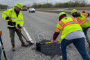 Indiana Department of Transportation workers patch a road.