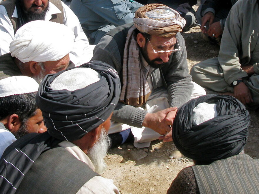 Haji Zahir, the new governor of Marjah in Helmand province, listens to residents' grievances Monday. It was the first time an Afghan government official visited the former Taliban stronghold in two years.