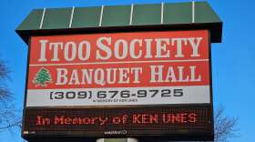 The Itoo Society's sign is shown with trees in the background. 