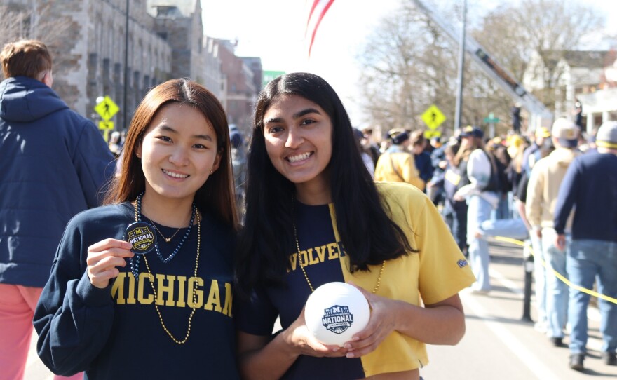 Isabel Lee and Deshana Betala, juniors at the University of Michigan, attend the parade, holding National Championship gear.