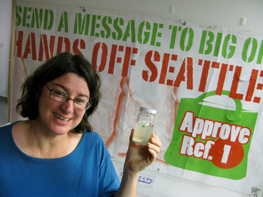 Heather Trim, a volunteer for the Seattle Green Bag Campaign, carries around a sample of polluted Pacific Ocean water.  She says the ocean's "great garbage patch" of non-biodegradable plastic fragments is the reason for her opposition to disposable plastic bags.