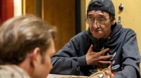 Sivaluaq Jerry "Bucket" Lieb tells a customer the story behind a design on one of his pieces at the Cama-i Dance Festival at Bethel Regional High School on March 30, 2019.