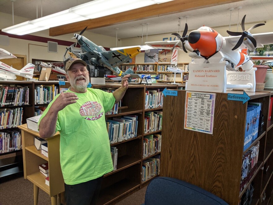 Norm Cosgrove shows off some of the remote-controlled model aircraft on display at the Delta Junior High library that he and members of the Delta-Greely RC Fliers club use.