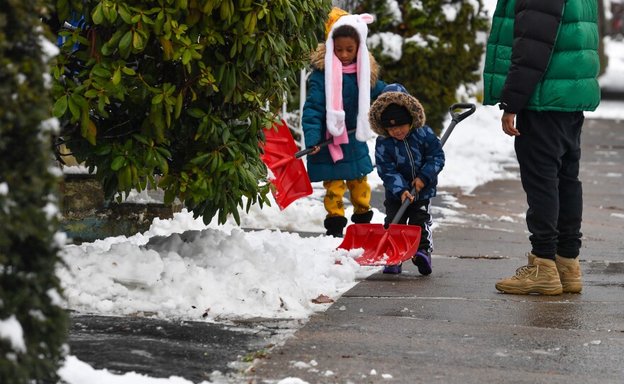 Keyara Ceruti, 6, and Tyreek Ceruti, 2, help their family shovel Sunday morning.