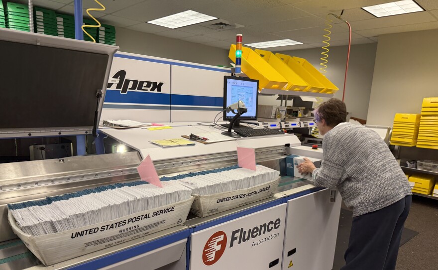 A Lane County Elections Office employee runs ballots through a signature verification machine, May 15, 2026.