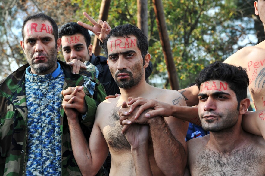 Their lips sewn shut in protest against limits on their movement, asylum-seekers from Iran wait to cross from Greece into Macedonia at the border near Idomeni, Greece, in November 2015.