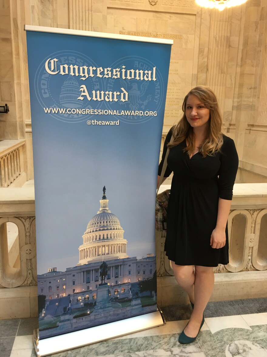 Elizabeth Walker, TTU incoming freshman, stand beside a sign at an award ceremony in Washington D.C. 