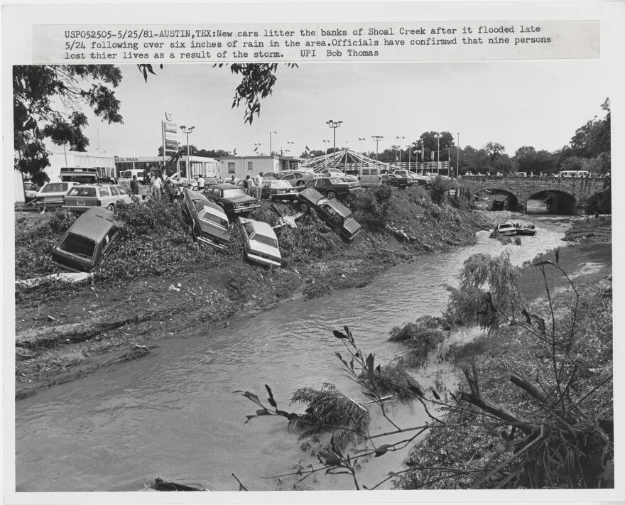 Cars from a dealership are along Shoal Creek, and some have fallen in, after the 1981 flood.