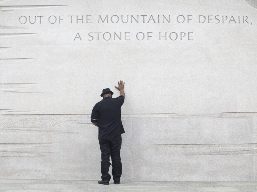 Rev. Bobby Turner or Columbus, Ohio, places his hand on the Martin Luther King Jr. Memorial on Thursday, in Washington, D.C.