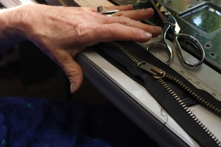 Bridget Milligan works with a zipper in her workshop at the Kodiak Coat Company. Photo by Annie Bartholomew/KTOO