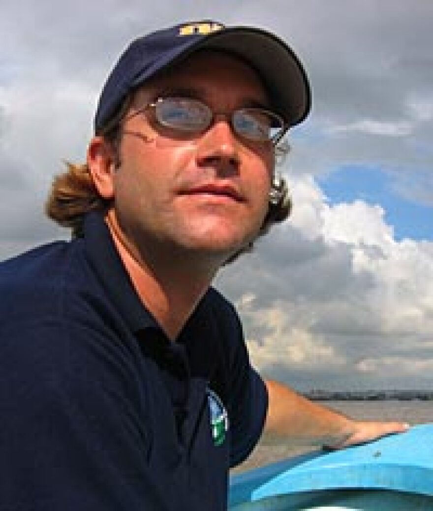 Zeb Hogan, pictured here traveling on the Tonle Sap River, is a National Geographic Society Emerging Explorer leading a project to identify and protect the world's largest freshwater fishes.