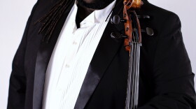 African man with long black hair holding his cello