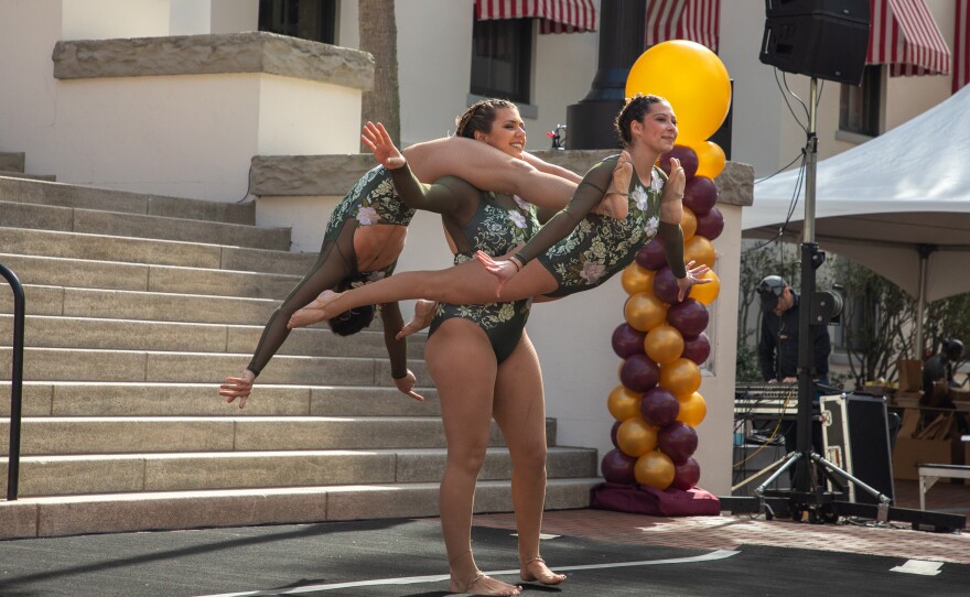 3 acrobats in formation intertwined with one another