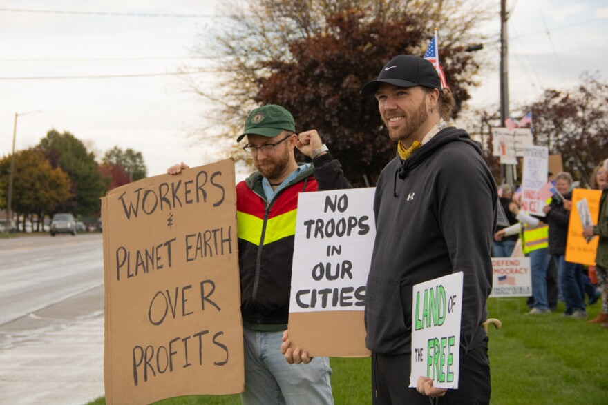 Michael Willett smiles as he stands beside fellow protesters at the No Kings protest in Mount Pleasant, Michigan on October 18, 2025.