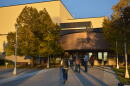 People stand outside of the entrance to a large building.