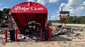 A pile of rubble with a sign over it that reads Baby Dolls.