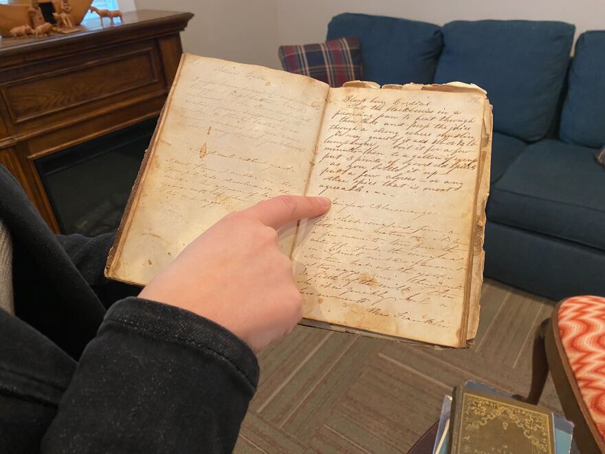 Erin Moulton shows off one of the old cookbooks in her collection.