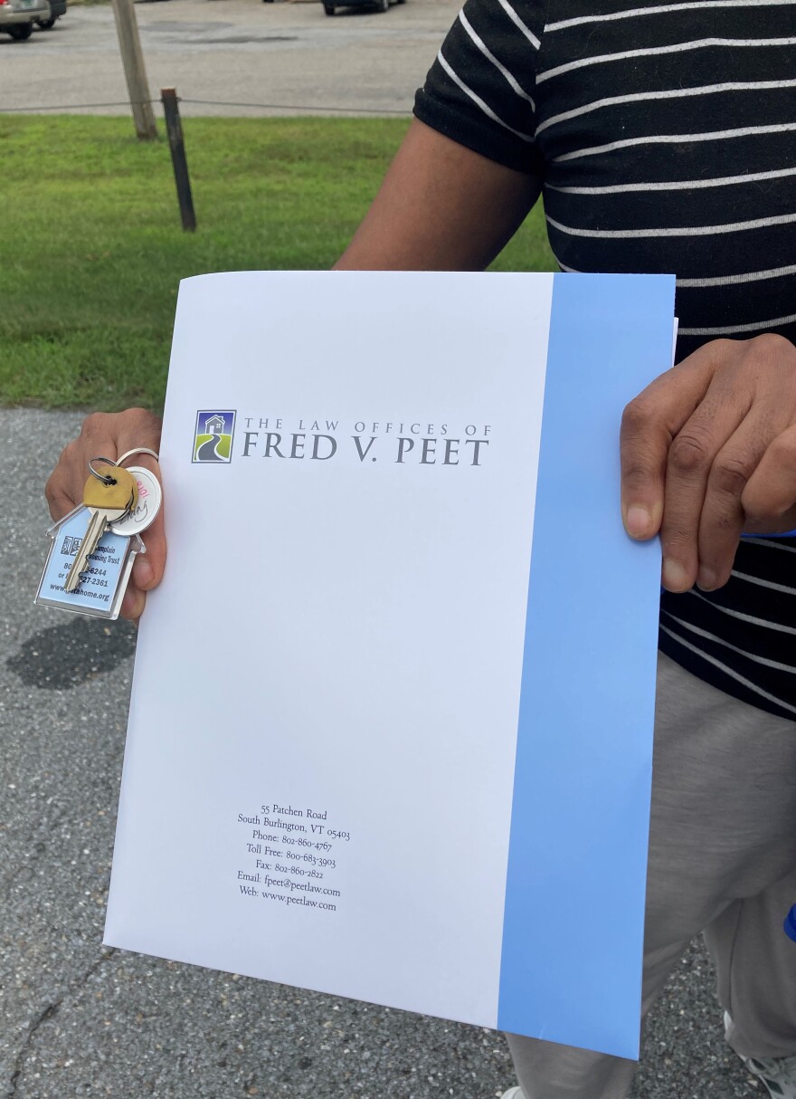 A pair of hands holding keys and a white folder.