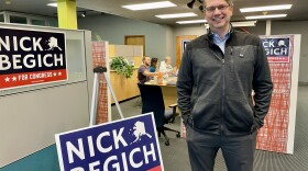 man in office with 'nick begich' signs
