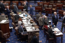 Sen. Mitch McConnell, wheeled out in a wheelchair, casts his first roll call vote since he was hospitalized after a fall in June.