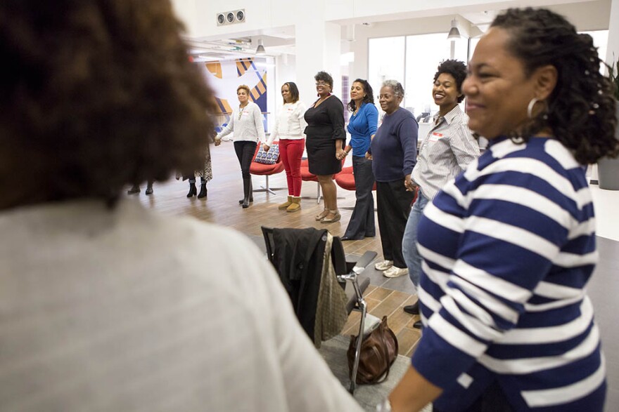 Women hold hands and share their thoughts about the strength of black women at the beginning of a Sister to Sister salon conversation at the Chesterfield in Durham on Friday, October 26, 2018.