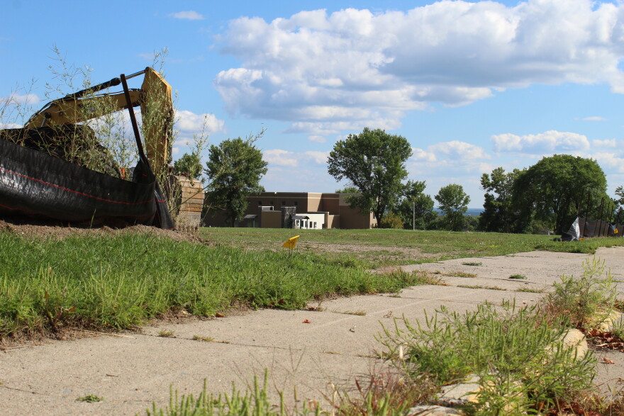 An excavator sits Aug. 27, 2026, in what used to be the Eveleth-Gilbert athletic fields. The Eveleth Community Center can be seen in the background.