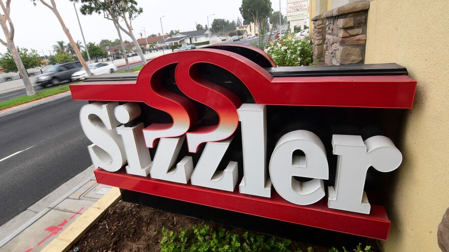 Sizzler USA has filed for bankruptcy as a result of the COVID-19 pandemic and related restrictions. Here, drivers pass a closed Sizzler restaurant in Montebello, Calif.