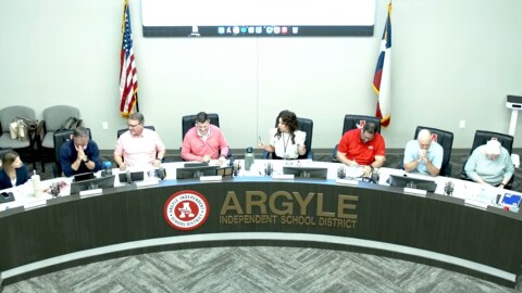 Adults sitting at a long school board meeting table