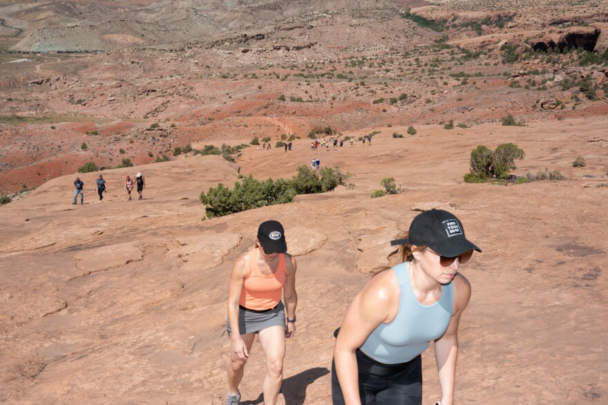 Visitors make the hike to Delicate Arch, three miles roundtrip.
