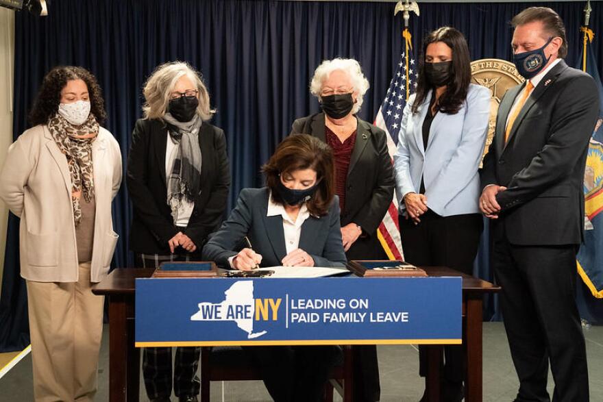 Gov. Kathy Hochul signs legislation Monday surrounded by four others