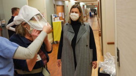 U.S. Rep. Elissa Slotkin, D-Holly, watches Michelle Calero put on protective gear as Calero prepares to visit her husband, who is being treated for COVID-19 at Sparrow Hospital in Lansing. Slotkin toured the hospital on Monday, Jan. 17. 2022.